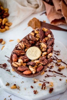 Stelle Cookierie | Ovo de Caramelo Salgado Cremoso, coberto com ganache de chocolate e finalizado com mix de nuts crocantes. 700 g, R$ 175