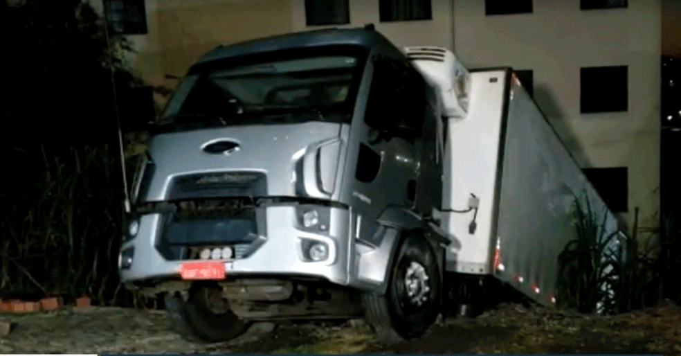 Caminhão fica suspenso após bater no muro entre estacionamento e condomínio em Pirituba; veículo foi roubado — Foto: Reprodução TV Globo