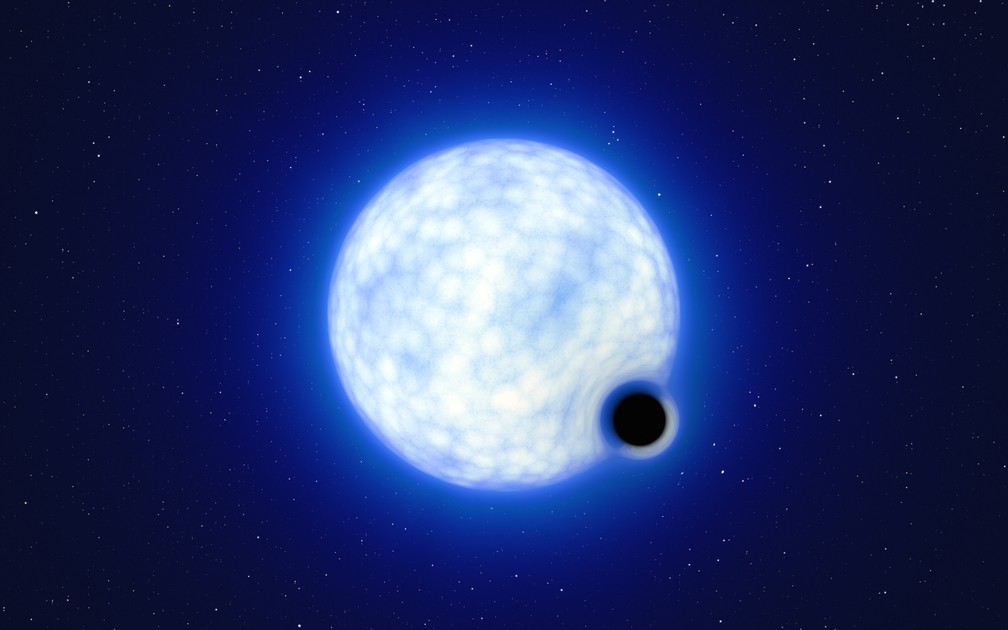 Representação artística mostra como seria o buraco negro. Escala da imagem não representa a realidade. A estrela azul ao centro é cerca de 200 000 vezes maior que o buraco negro. — Foto: ESO/L. Calçada