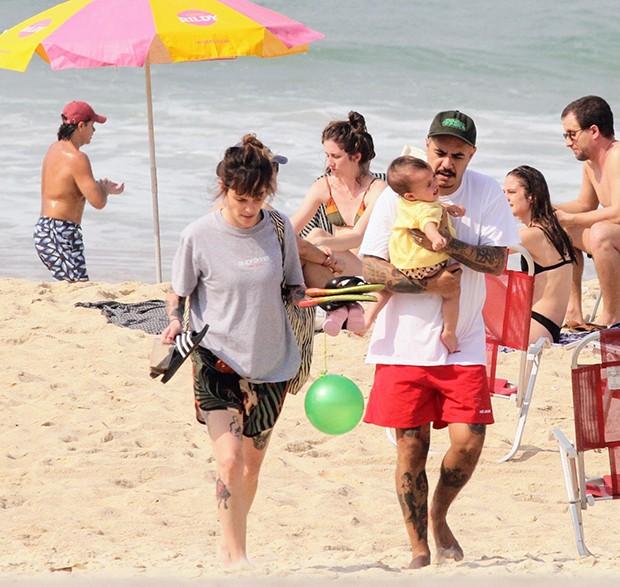 Marcelo D2 e a mulher, Luiza Machado, curtiram praia com a pequena Maria Luiza (Foto: Dan Delmiro / AGNews)