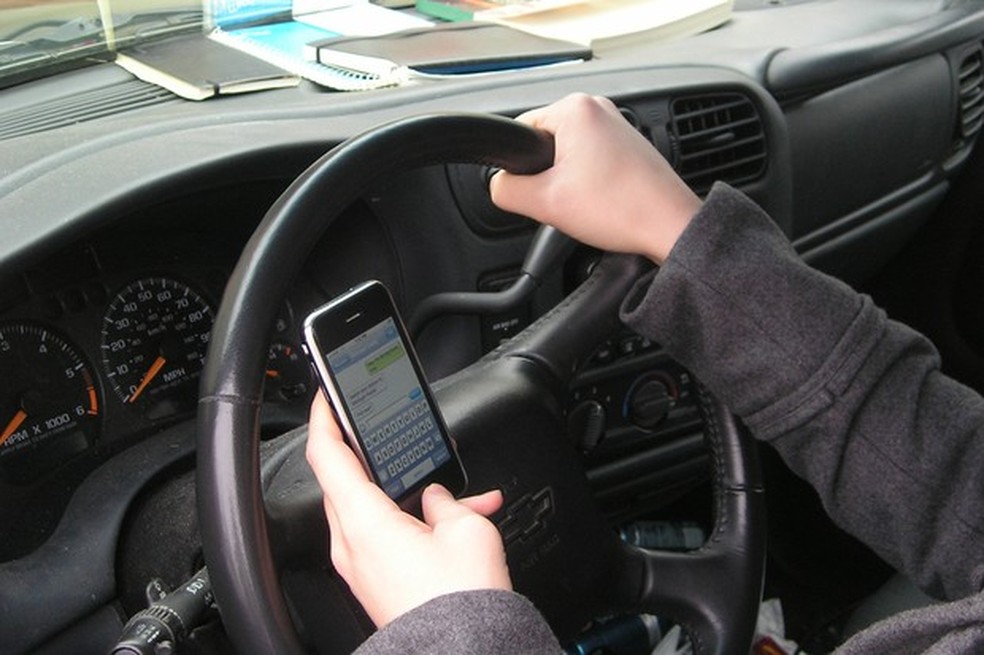 Usar o celular ao volante é uma infração gravíssima que resulta em multa de R$ 293,47 e sete pontos na CNH — Foto: Divulgação