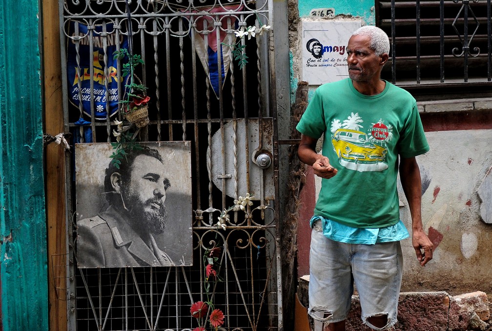 Homem em frente a um poster de Fidel Castro em Havana (Foto: Yamil Lage/AFP)