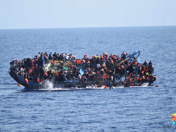 Imigrantes pulam de um barco durante naufrágio antes da chegada do resgate pelos navios 'Bettica' e 'Bergamini' da marinha italiana na costa da Líbia  (Foto: Marinha italiana/Divulgação via Reuters)
