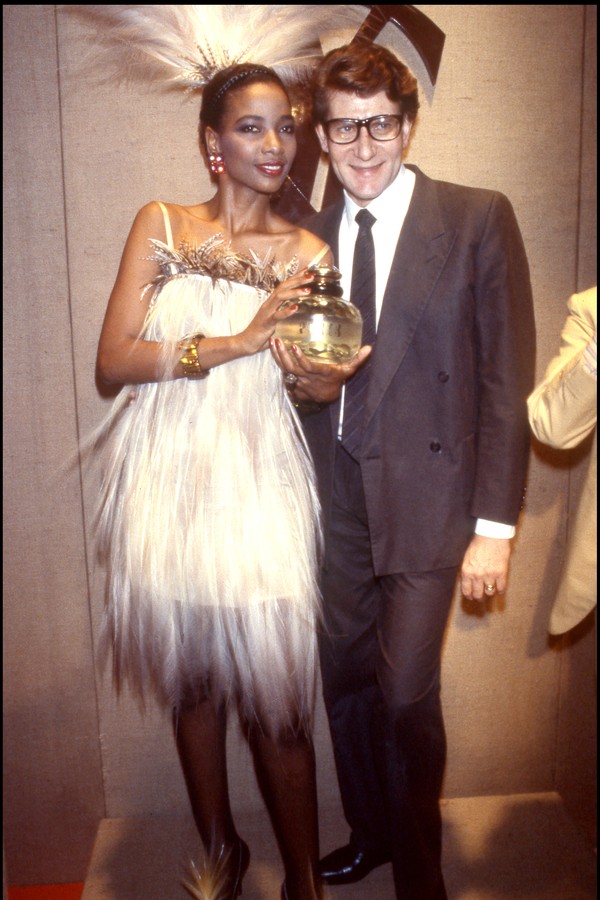 Model Mounia with "Paris" perfume bottle posing with Yves Saint Laurent, at the 1984-1985 Fall/Winter Haute Couture collection. (Photo by Bertrand Rindoff Petroff/Getty Images) (Foto: Getty Images)