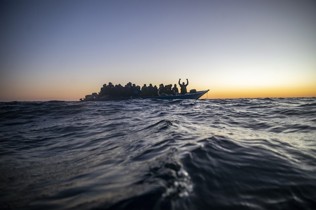 12 de fevereiro - Migrantes e refugiados de várias nacionalidades africanas aguardam ajuda a bordo de um barco de madeira superlotado no Mar Mediterrâneo — Foto: Bruno Thevenin/AP