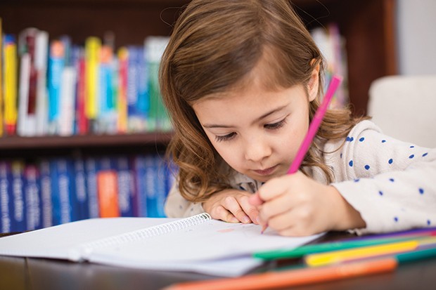 Little girl sitting at table drawing with color pencils at home (Foto: Getty Images)