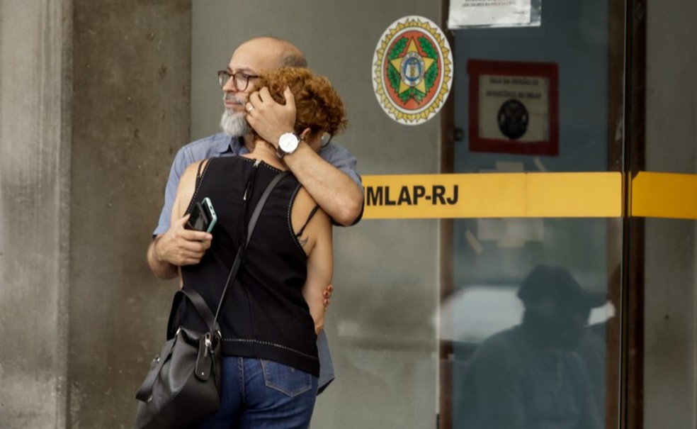 Isabella Barbosa Meireles, filha de Alair, é consolada pelo marido, Roberto Carlos,  na porta do IML — Foto: Gabriel de Paiva