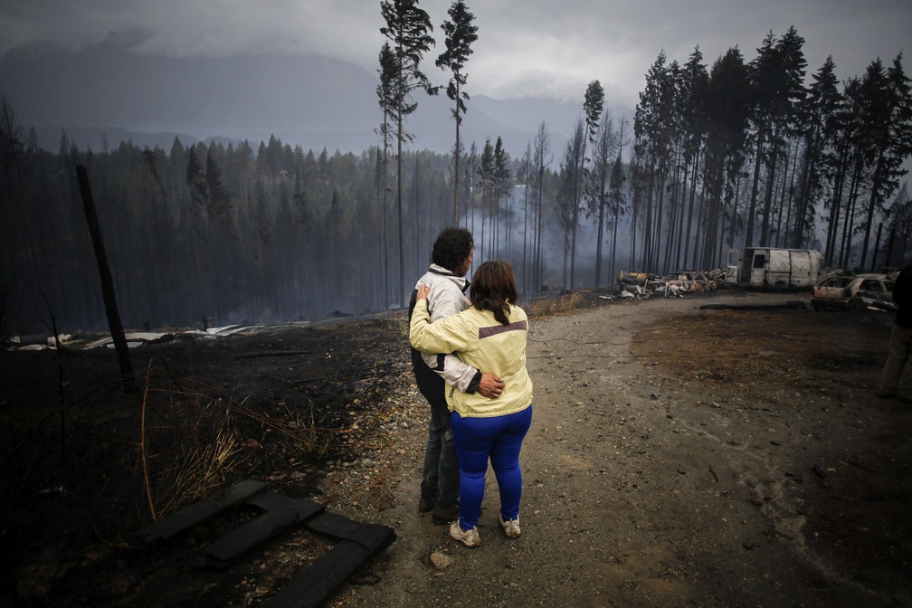 Casal se abraça diante da fumaça deixada pelos incêndios que atingem florestas da Patagônia argentina — Foto: Matias Garay/AP Photo