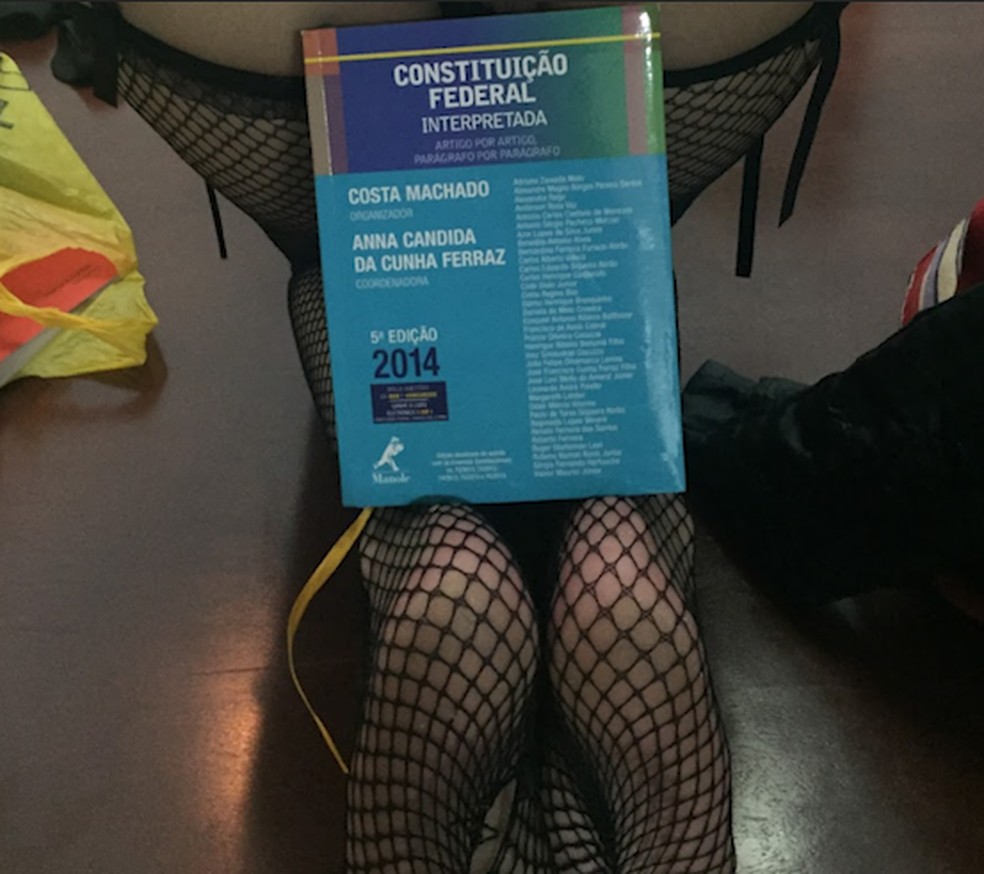 Mulher posa com livro sobre a Constituição com artigo do juiz Valmir Maurici Júnior — Foto: Reprodução