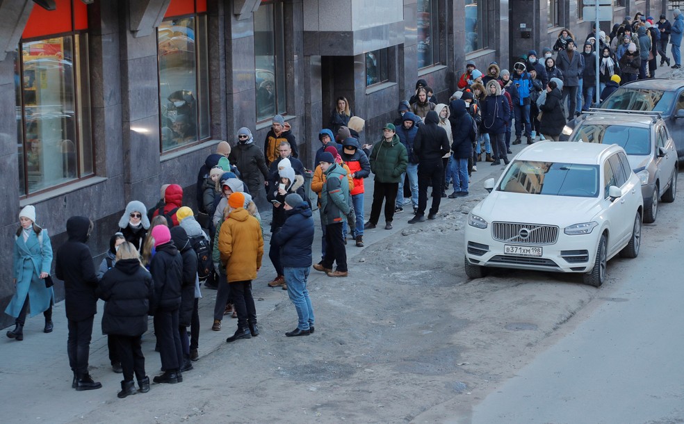 Russos fazem fila para sacar dinheiro em caixa eletrônico em São Petersburgo no domingo (27) — Foto: Anton Vaganov/Reuters