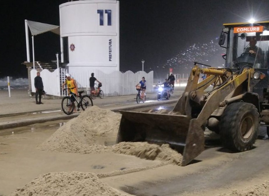 Equipes da Comlurb tiveram trabalho para limpar a pista que ficou cheia de areia por causa da ressaca
