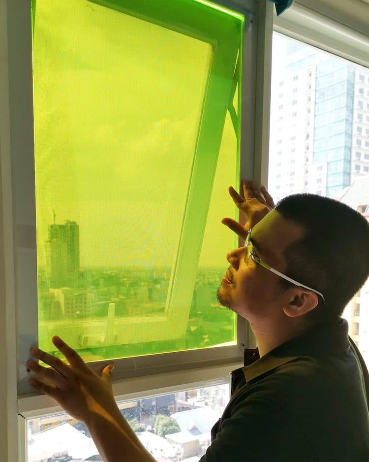Carvey Ehren Maigue aplicando o painel em uma janela (Foto: James Dyson Award / Divulgação)
