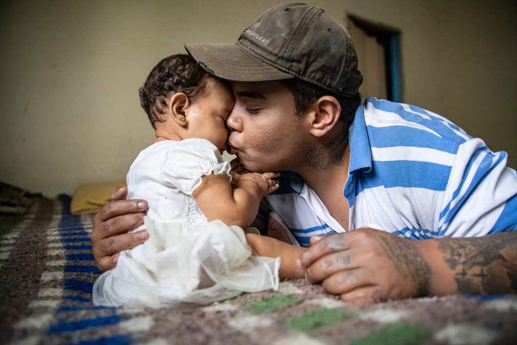 Em casa, Hélio beija sua filha, Victória, de 8 meses — Foto: Fábio Tito/g1