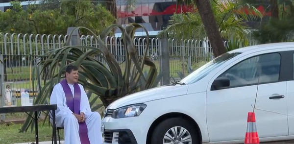 Padre recebendo fiéis por meio de atendimento drive-thru no DF — Foto: Reprodução TV Globo