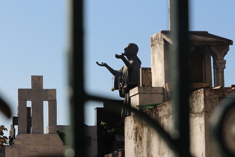 Em algumas cidades, parentes podem acompanhar de fora do cemitério o sepultamento — Foto: Carlos Dias/G1