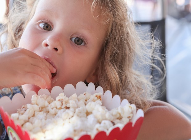 Criança comendo pipoca (Foto: Thinkstock)