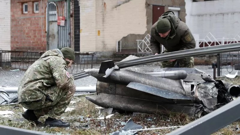 Policiais inspecionam fragmentos de um míssil que caiu numa rua da capital Kiev, logo após Putin determinar a invasão da Ucrânia (Foto: Valentyn Ogirenko/Reuters via BBC News)