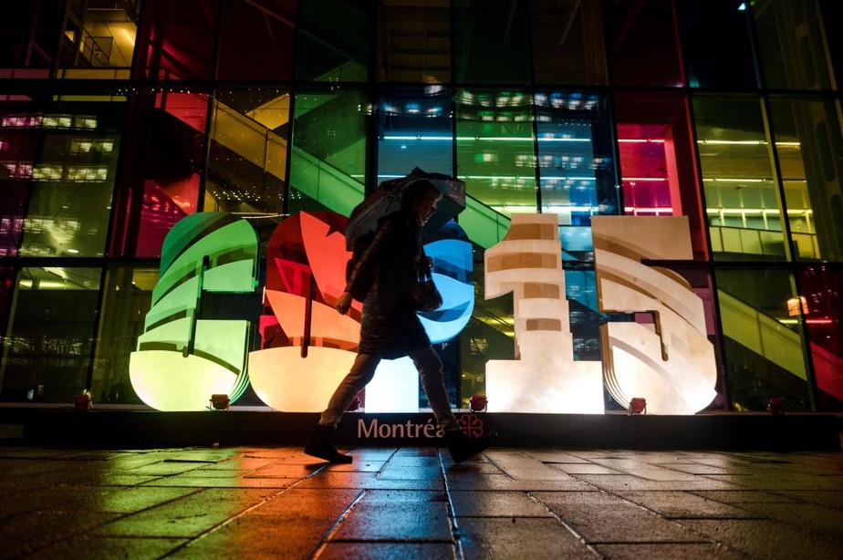 Uma pessoa caminha pelo sinal iluminado da Conferência de Biodiversidade das Nações Unidas (COP15), em Montreal