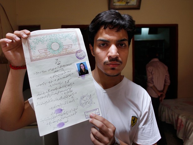 Hassan Khan, marido da vítima, mostra o certificado de casamento (Foto: K.M. Chaudary/AP)