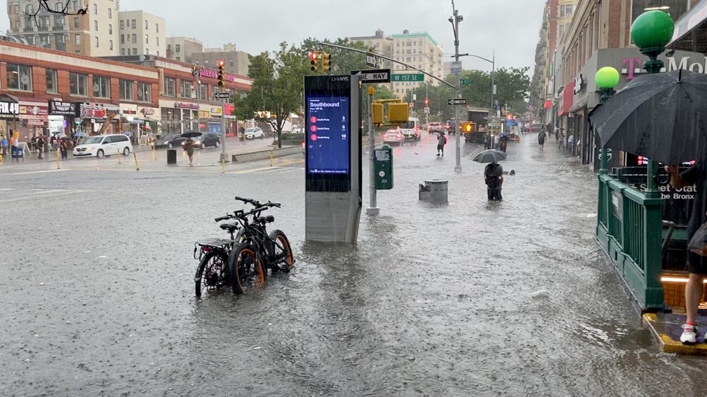 Pessoa atravessa área alagada pelas chuvas perto da estação de metrô 157th St. em Nova York, nos Estados Unidos, em 8 de julho de 2021 — Foto: Stephen Smith/Reuters