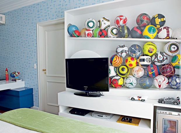 O dono deste quarto, um menino de 11 anos com uma enorme coleção de bolas de futebol, queria um espaço para guardar e expor sua paixão. A arquiteta Sabrina Matar desenvolveu uma estante que reúne TV, videogame e os brinquedos em um só lugar (Foto: Edu Castello)