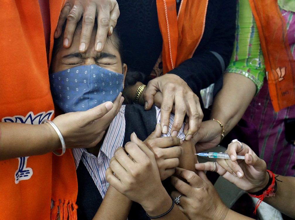 Uma menina reage ao receber uma dose da vacina contra a Covid-19 durante uma campanha de vacinação para crianças de 15 a 18 anos em Ahmedabad, na Índia, nesta segunda-feira (3)   — Foto: Amit Dave/Reuters