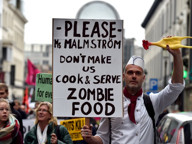 Não nos faça cozinhar e servir comida de zumbi, diz cartaz em protesto contra acordo de livre comércio em Bruxelas, neste sábado (17) (Foto: Reuters/Eric Vidal)