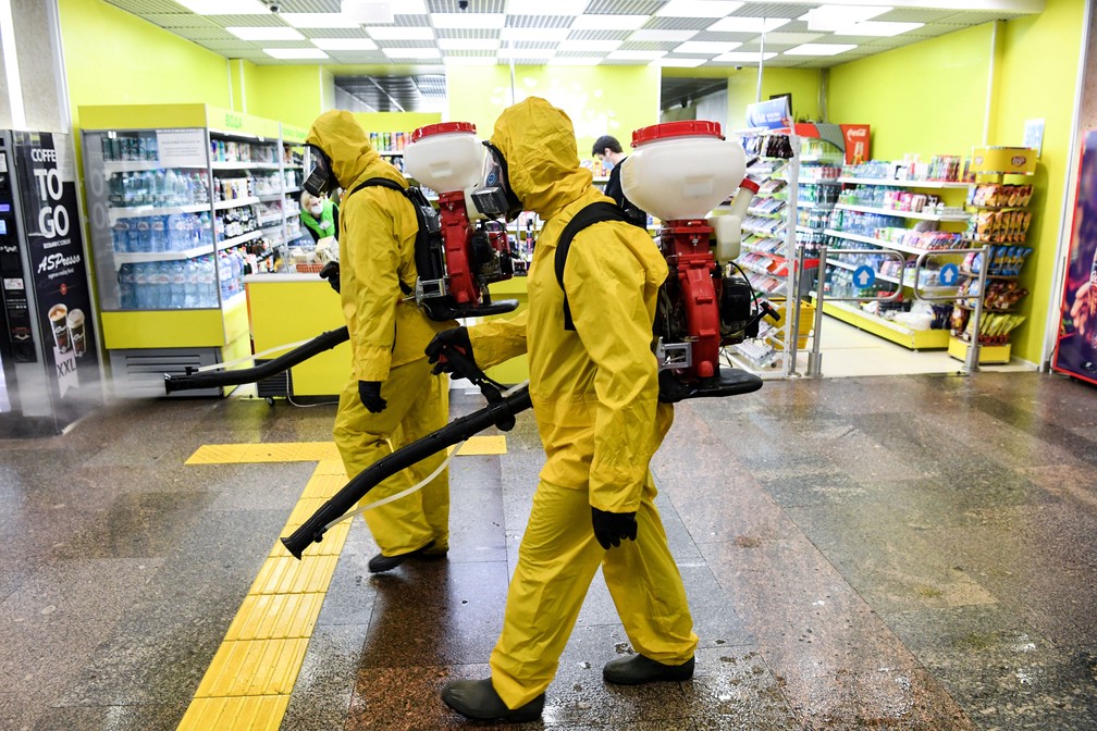 Militares do Ministério de Emergências da Rússia, usando equipamento de proteção, desinfetam a estação ferroviária de Leningradsky, em Moscou, nesta terça-feira (19)  — Foto: Kirill Kudryavtsev / AFP