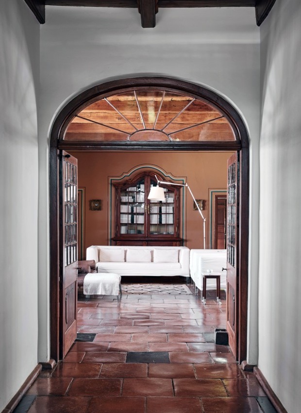 A porta dupla, com seu elegante painel de vidro, abre-se para a sala de estar mobiliada com sofás de Philippe Starck para a Driade e a luminária Tolomeu da Artemide (Foto: Greg Cox / Bureaux)