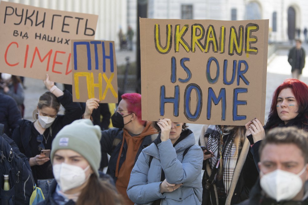 Manifestantes exibem cartaz com os dizeres "Ucrânia é nossa casa" em frente ao Ministério de Relações Exteriores, em Viena, na Áustria. — Foto: ALEX HALADA / AFP