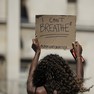 Foto: (Mulher segura um pedaço de papelão com as frases 'eu não consigo respirar', dita por George Floyd antes de morrer, e 'black lives matter' ('vidas negras importam', em português), durante protesto pela morte dele em Londres, no Reino Unido, neste domingo (31). / Matt Dunham/AP)