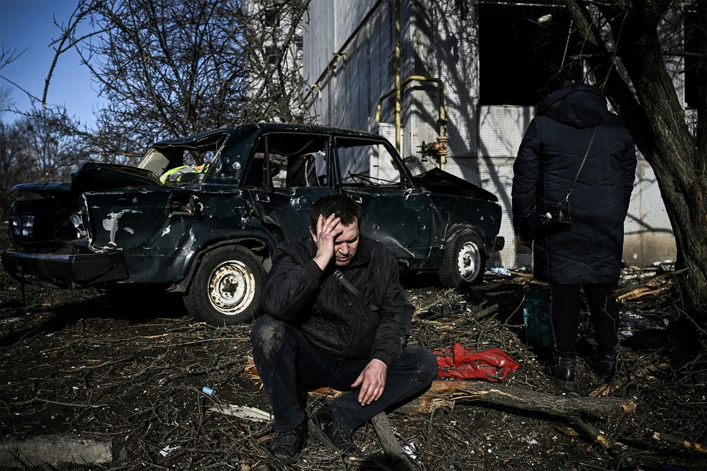 Homem fica do lado de fora de prédio destruído após bombardeios na cidade de Chuguiv, no leste da Ucrânia, em 24 de fevereiro de 2022 — Foto: Aris Messinis/AFP