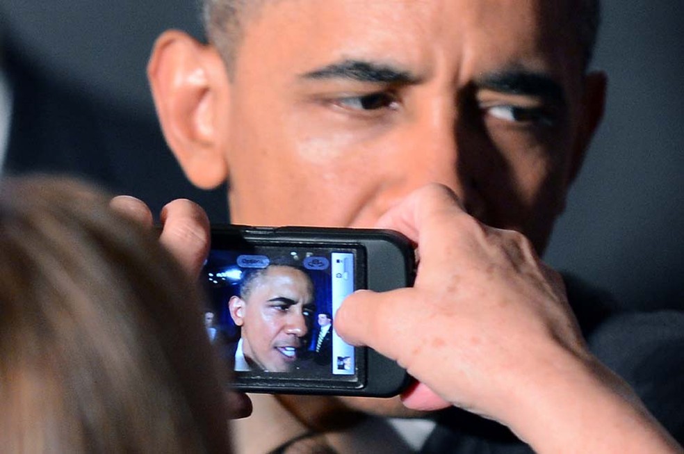 Mulher tira fotos de presidente dos EUA, Barack Obama, com seu telefone celular durante uma recepção em Atlanta, Geórgia. (Foto: Jewel Samad/AFP)