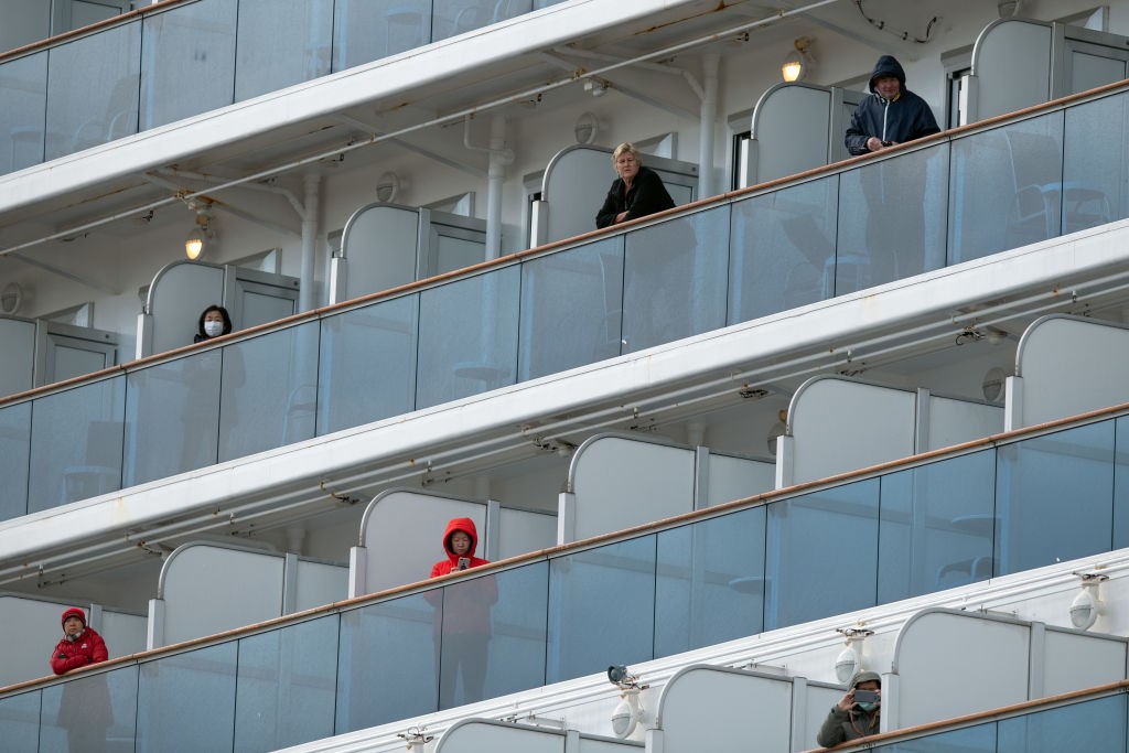 YOKOHAMA, JAPAN - FEBRUARY 06: Passengers look out from balconies on the Diamond Princess cruise ship while it is docked at Daikoku Pier where it will be resupplied and newly diagnosed coronavirus cases taken to hospital while it remains in quarantine off (Foto: Getty Images)