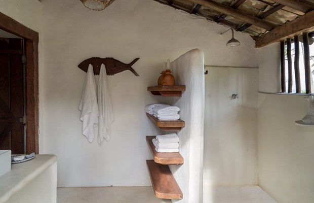 Banheiro | Em vez de armários, apenas prateleiras de cumaru compõem a área. O pendente de bambu foi feito pelos indígenas pataxós e o cabideiro em formato de peixe pelo artesão João Luz Calazans (Foto: Evelyn Müller/Editora Globo)