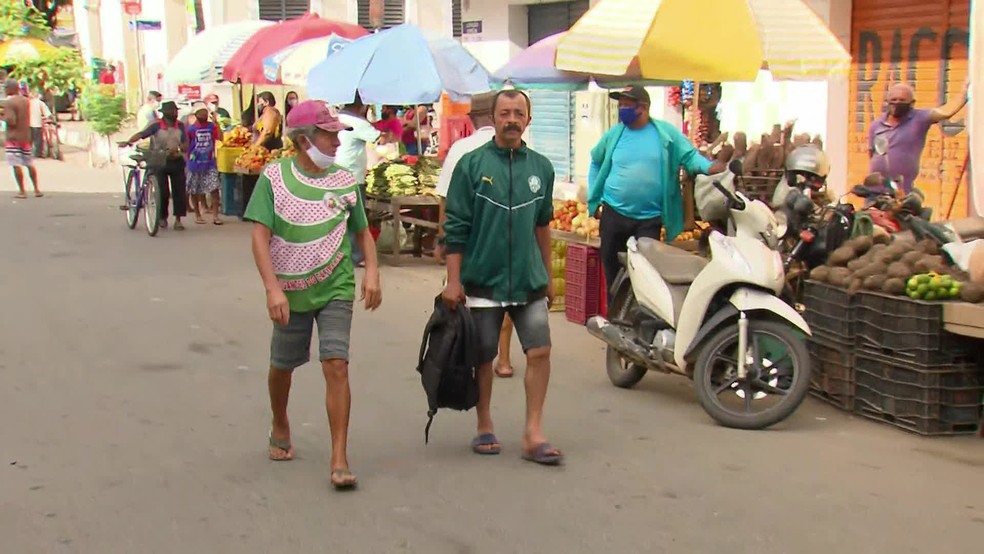Homens sem máscaras transitando pela Feira de Mangaio em Limoeiro, na manhã desta terça (26), início da nova quarentena no estado — Foto: Reprodução/TV Globo