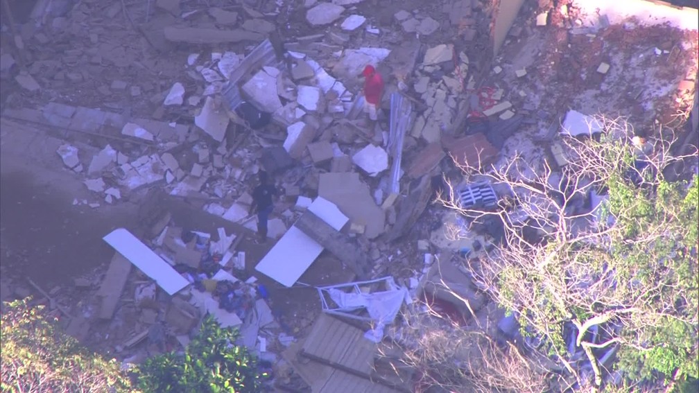 Moradores fazem busca em prédio que desabou na Muzema, que foi uma das áreas mais atingidas pelo temporal que caiu no Rio. A cidade está em estágio de crise desde segunda-feira (7). — Foto: Reprodução/ TV Globo