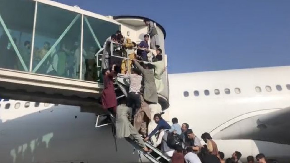 Pessoas tentam entrar em aviões para fugir do Afeganistão no aeroporto internacional de Cabul — Foto: Sahar Rahimi/BBC