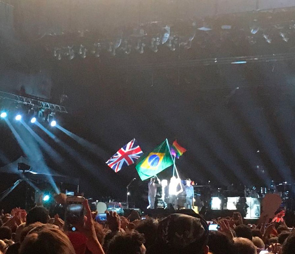 Paul segura bandeira do Brasil durante show; bandeiras britânica e LBGT também estiveram no palco (Foto: Rafaela Rodrigues/Arquivo pessoal)