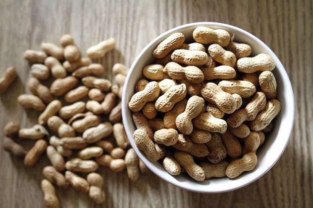Bowl of peanuts on wooden table (Foto: Getty Images)