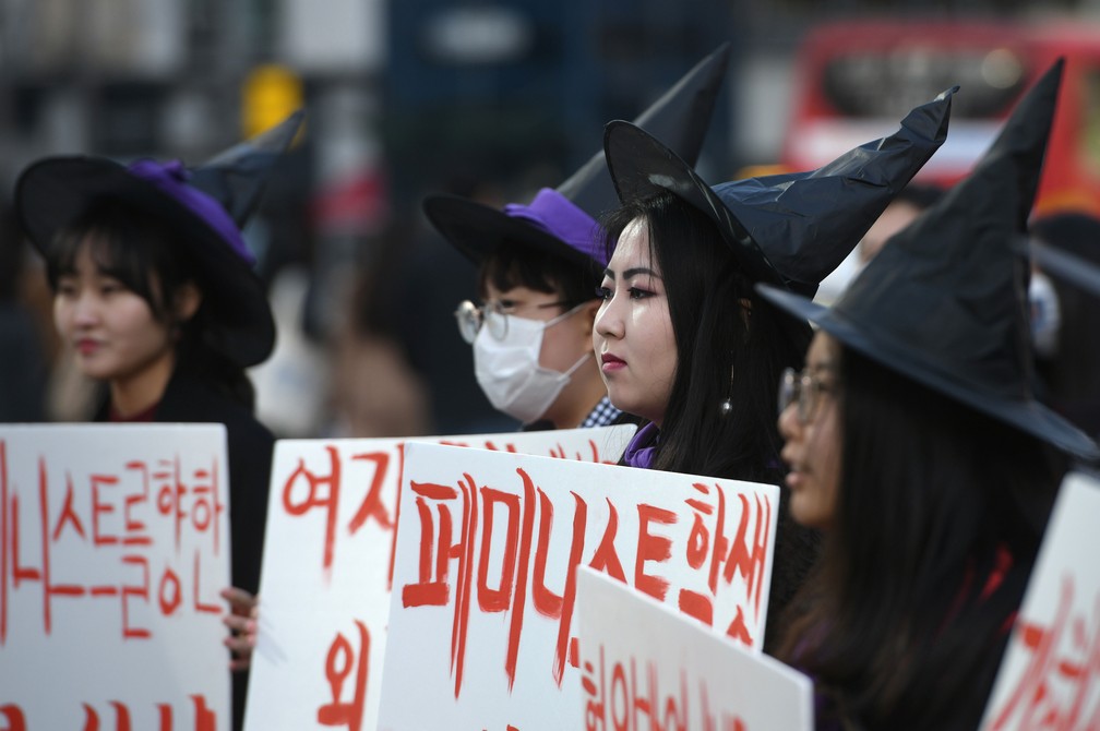 Sul-coreanas com chapéus de bruxas participam de manifestação em Seul, nesta sexta-feira (8), Dia da Mulher  — Foto: Jung Yeon-Je / AFP