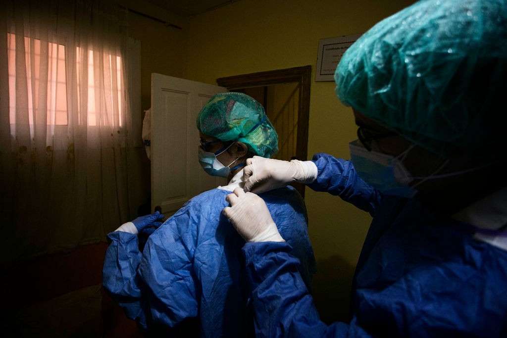 A nurse helps the doctor to put on the EPI (Individual Protective Equipment), before making a medical visit to a patient in Ciutat Meridiana, in Barcelona, on April 19, 2020. (Photo by Robert Bonet/NurPhoto via Getty Images) (Foto: NurPhoto via Getty Images)