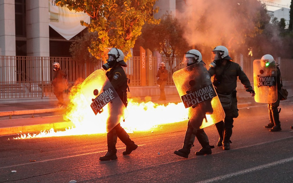 Policiais são vistos próximos a chamas na embaixada dos EUA em Atenas, durante protesto contra a morte de George Floyd, na quarta-feira (3) — Foto: Reuters/Alkis Konstantinidis 