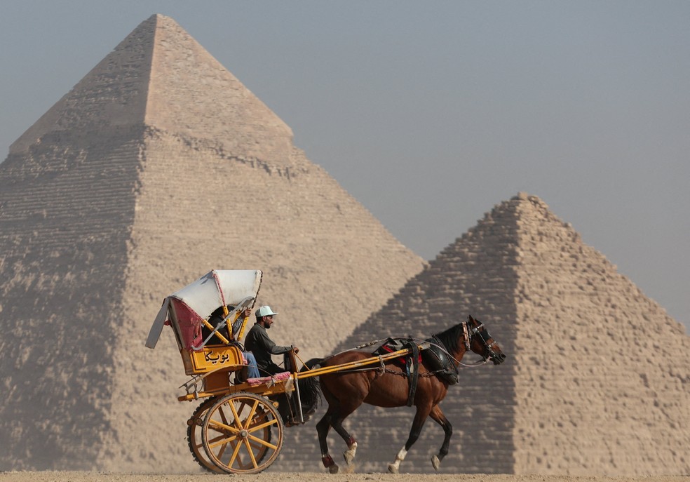 Turistas andam de carroça em frente ao planalto das Grandes Pirâmides em Gizé, no Egito, em imagem de dezembro de 2022. — Foto: REUTERS/Amr Abdallah Dalsh/Imagem de Arquivo