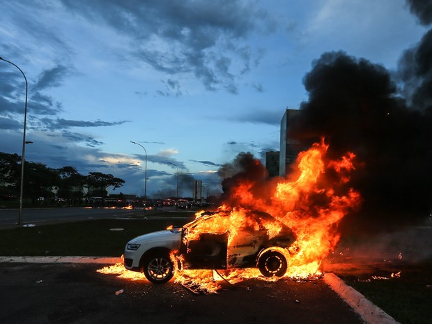 Um carro em chamas é visto durante um protesto na Esplanada dos Ministérios, em Brasília, contra a PEC 55, que limita os gastos públicos para os próximos 20 anos (Foto: Dida Sampaio/Estadão Conteúdo)