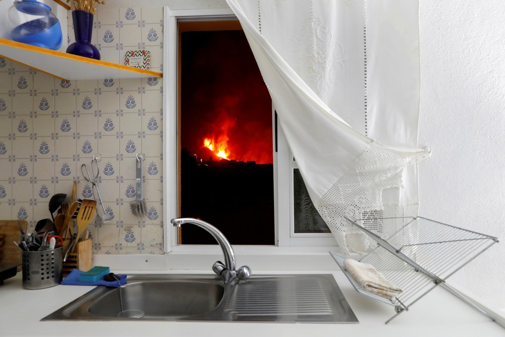 28 de setembro - O vulcão Cumbre Vieja em erupção é visto da janela de cozinha de uma casa na ilha de La Palma, no arquipélago espanhol das Canárias — Foto: Jon Nazca/Reuters