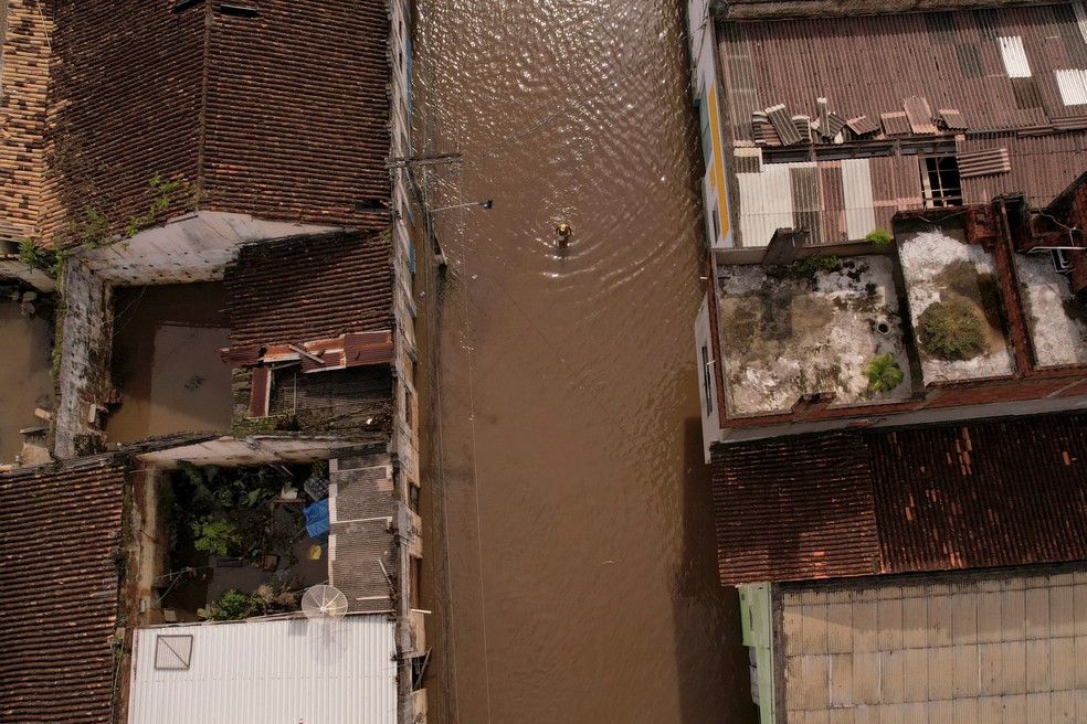 Foto aérea mostra uma pessoa caminhando em uma rua inundada após fortes chuvas em Itajuipe, no sul da Bahia, nesta segunda (27) — Foto: Amanda Perobelli/Reuters