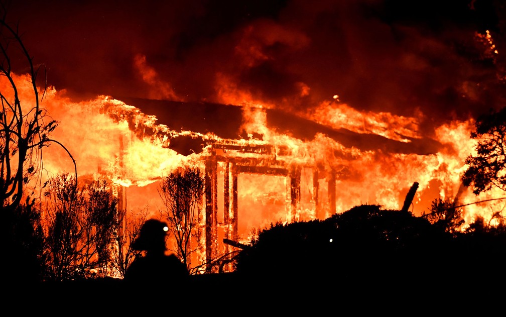 Bombeiros combatem incêndio em uma casa em Napa, na Califórnia, na segunda-feira (9) (Foto: Josh Edelson/AFP)