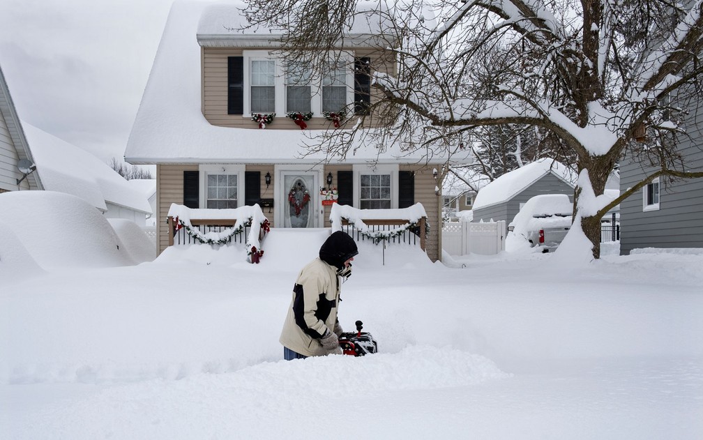 Homem remove neve em frente de casa em Binghamton, NY, na quinta-feira (17) — Foto: AP Photo/Craig Ruttle