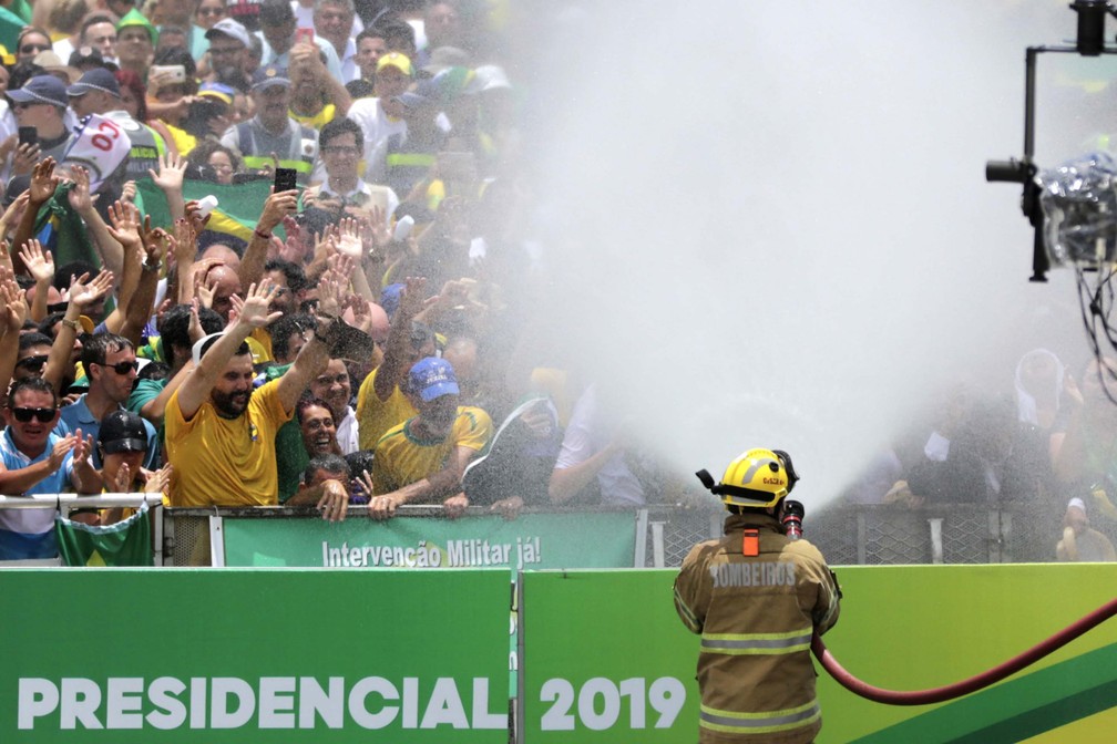 Bombeiros refrescam público em frente ao Palácio do Planalto, em Brasília (DF), antes da cerimônia de posse do presidente — Foto: Fátima Meira/Futura Press/Estadão Conteúdo